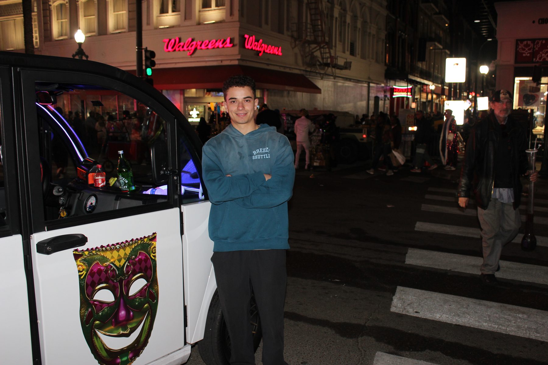 Tristan Sariego standing beside a Breeze shuttle downtown at night